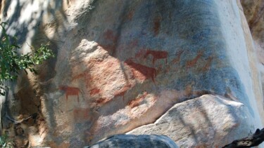 Rostbraune Felsmalereien zieren einen Sandsteinfels der Tsodilo Hills in Botswana