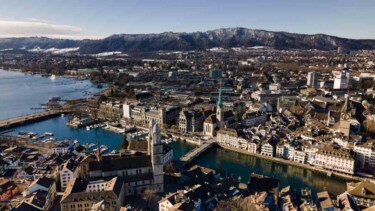 Zuerich Stadt, Work-Life-Balance, Kirche, Fluss, Häuser, Berge [Quelle: unsplash.com, Autor: Patrick Federi]