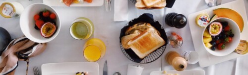 Frühstück auf weiß gedecktem Tisch im Restaurant [Quelle: pexels.com]