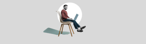 Ein Mann sitzt mit Laptop auf dem Schoß auf einem Stuhl. Die Beine baumeln in der Luft.