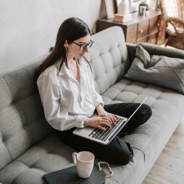 Frau am Laptop sitzend auf dem Sofa zuhause [Quelle: pexels.com]