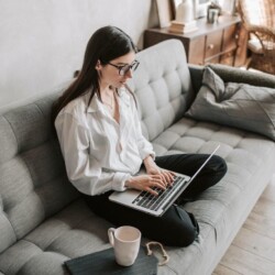 Frau am Laptop sitzend auf dem Sofa zuhause [Quelle: pexels.com]