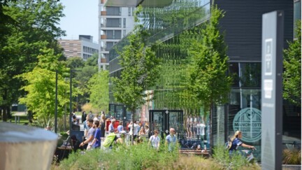Der Campus der Alliance Manchester Business School mit Bäumen und vielen Menschen