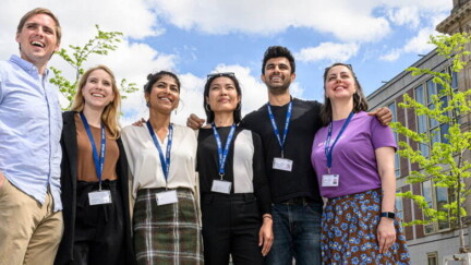 6 Studierende stehen lächelnd vor der ESMT