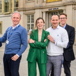 4 Personen stehen lächelnd vor der ESMT