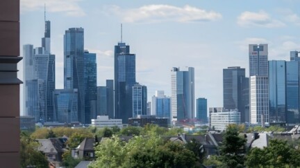 Die Skyline von Frankfurt am Main. Im Vordergrund eine Hausfassade.
