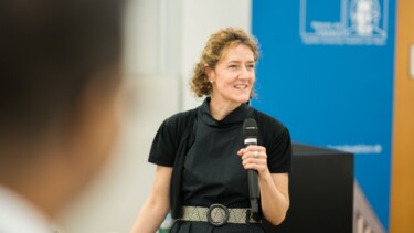 Eine Frau spricht in ein Mikrofon.