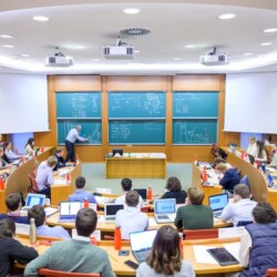 Studierende sitzen im Hörsaal und hören zu.