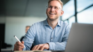 Ein Student hört der Vorlesung zu und macht sich Notizen.