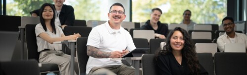 Studierende sitzen im Hörsaal und hören der Vorlesung zu.