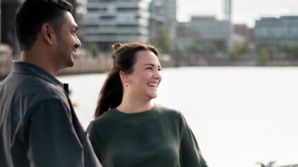 Drei Studierende stehen am Wasser und unterhalten sich