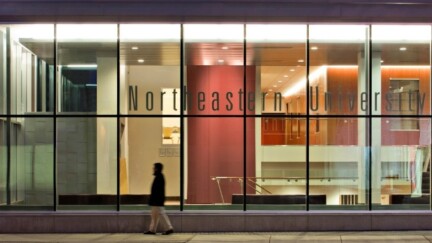 Ein Gebäude mit Glas-Fassade bei Nacht mit dem Schriftzug Northeastern University School of Law