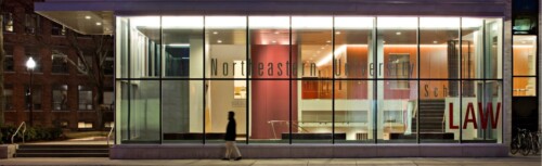 Ein Gebäude mit Glas-Fassade bei Nacht mit dem Schriftzug Northeastern University School of Law