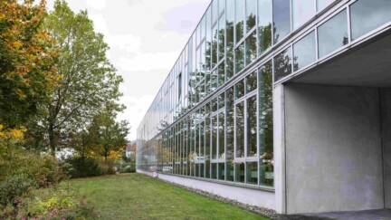 Ein Gebäude mit vielen Fenstern im Grünen.