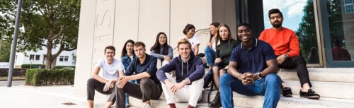 Studenten der Universität zu Köln sitzen auf der Treppe.