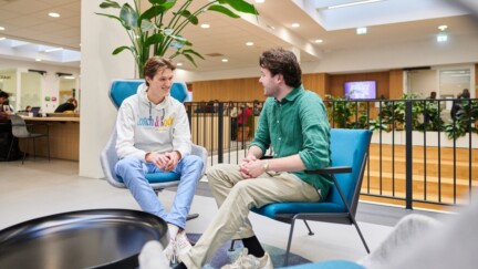 Zwei Studenten sitzen in Sessel in einem Foyer der University of Groningen