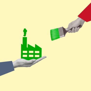 Hand hält eine Fabrik. Sie wurde von einem Pinsel, der in einer anderen Hand ist, grün angemalt.