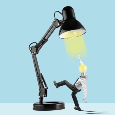 Eine Person mit Glühbirne als Kopf steht unter einer riesigen Schreibtischlampe. Es sieht aus, als würde er die Lampe hochklettern wollen.