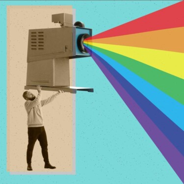 Person hält einen altmodischen Projektor. Das Licht, das aus dem Projektor kommt, ist in die Farben des Regenbogens aufgespalten.