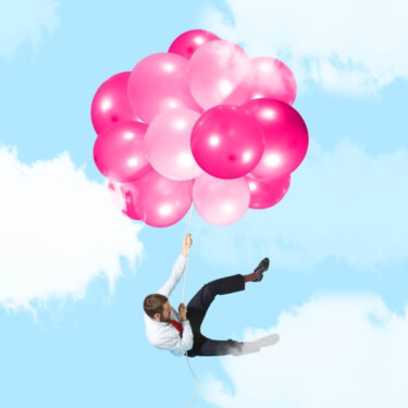 Geschäftsmann kämpft gegen rosa Luftballons