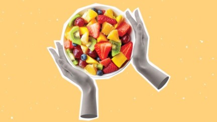 Schüssel mit Obstsalat die von zwei Händen gehalten werden