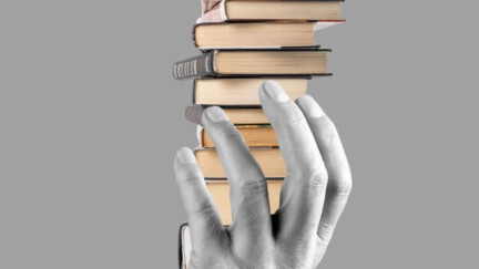 Eine Hand hält einen Stapel Bücher.