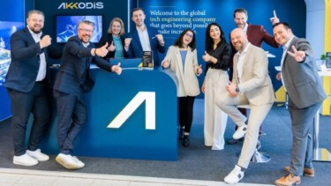 Mitarbeiter:innen von Akkodis stehen an einem Messestand, lächeln in die Kamera und zeigen den Daumen hoch.