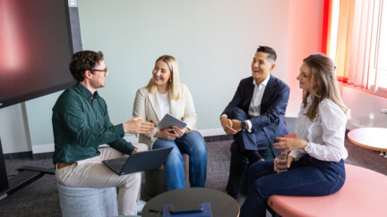 Vier Mitarbeitende der Allianz sitzen zusammen in einem Konferenzraum