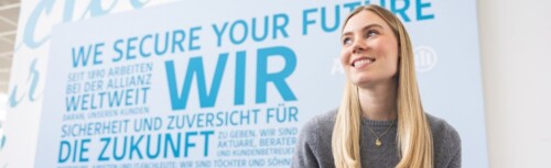 Frau sitzt vor einem Plakat