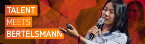 Auf dem Bild sieht man rechts eine Frau mit Mikrofon und ausgestreckter Hand, links vor orange-rotem Hintergrund den Schriftzug Talent Meets Bertelsmann