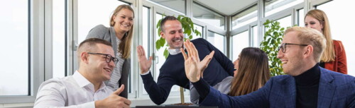 Mitarbeiter von Camelot machen High-five.