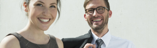 Frau und Mann von CTcon im Anzug lächeln.