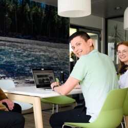 Drei Menschen haben ein Meeting an einem Tisch