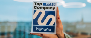 Zwei Hände halten ein Schild hoch mit der Aufschrift "Top Company 2025"