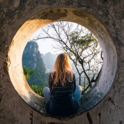 Frau sitzt in rundem Beton