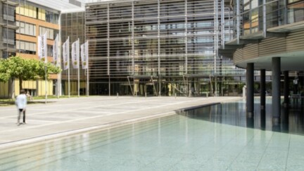 Das Firmengelände der HUK-Coburg mit einem künstlichen See und Fahnen im Hintergrund.