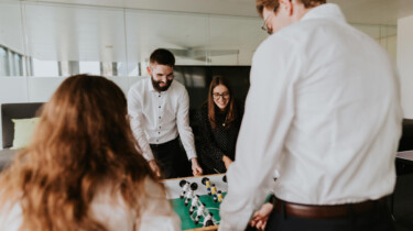 Mitarbeitende spielen Kicker