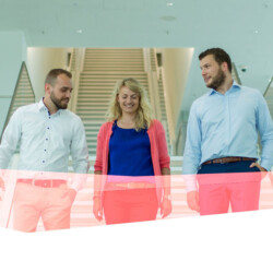 Drei Mitarbeiter der ﻿HypoVereinsbank laufen die Treppe runter und unterhalten sich.