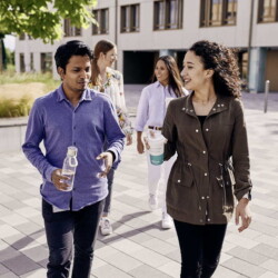 Zwei Studierende laufen auf dem Campus.
