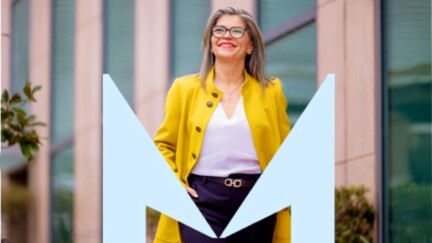 Eine Frau in einer gelben Jacke schaut nach oben.