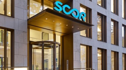 Ein Gebäude von SCOR mit einer Drehtür. Über der Tür ein türkiser Schriftzug "SCOR"