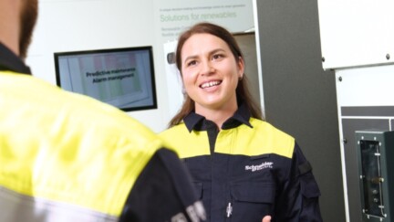 Eine Frau in Dienstkleidung lächelt in die Kamera.