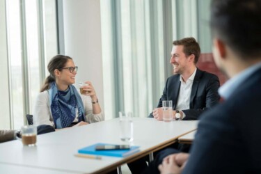 Mitarbeitende sitzen am Schreibtisch