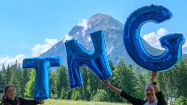 Mitarbeiterinnen halten TNG-Luftballons