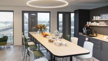 Küche mit langer Tafel, Snacks und Kaffeemaschine.