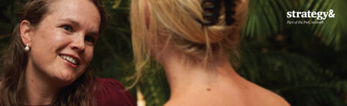 Zwei Frauen im Gespräch, eine von vorne und eine von hinten zu sehen vor einem grünen Hintergrund, rechts oben das Logo von Strategy&