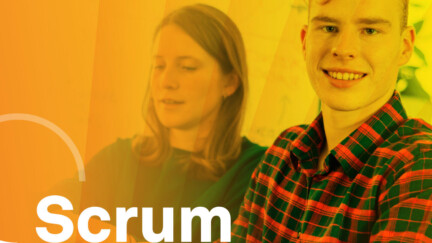 drei Personen am Schreibtisch vor orange-gelbem Hintergrund, in der linken Ecke steht Scrum