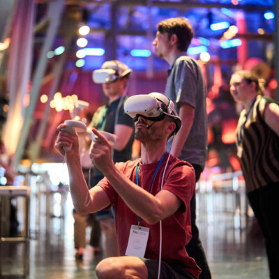 Mann mit VR-Brille vor buntem Hintergrund